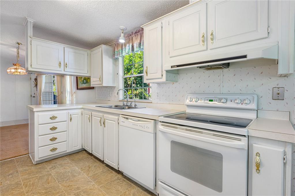 509 Starboard Avenue Edgewater, FL 32141 - Photo 13 of 54 a kitchen with granite countertop white cabinets and white appliances