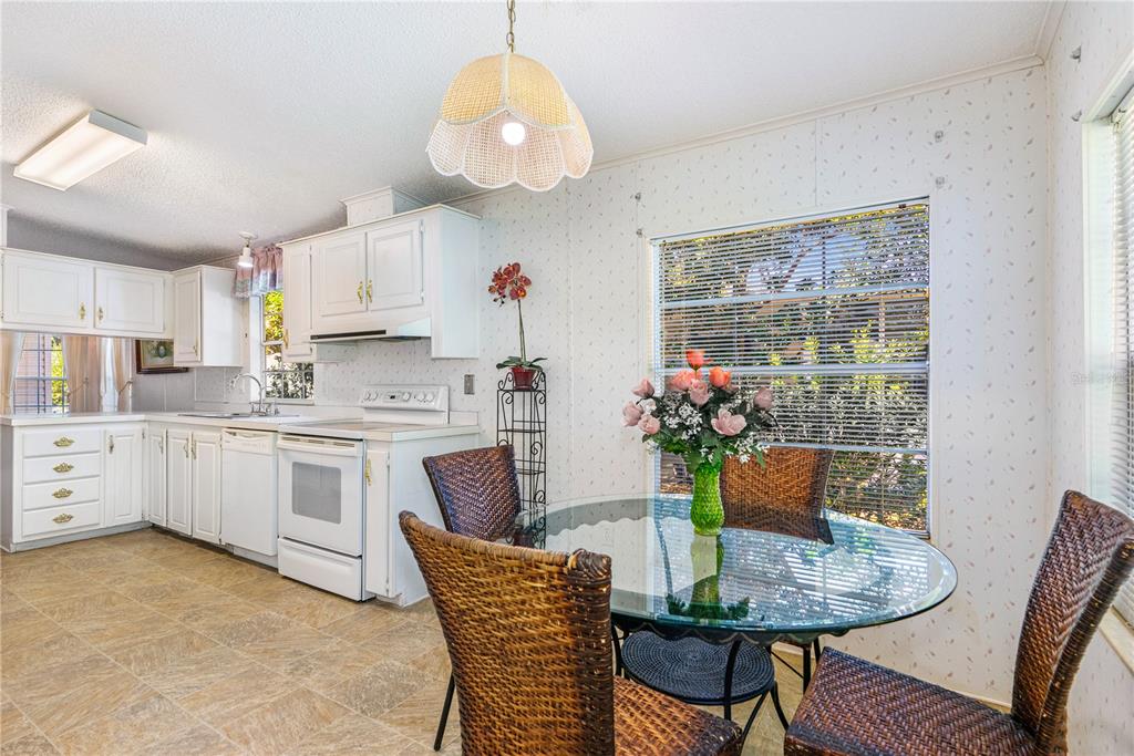 509 Starboard Avenue Edgewater, FL 32141 - Photo 15 of 54 a kitchen with stainless steel appliances granite countertop a dining table chairs and white cabinets