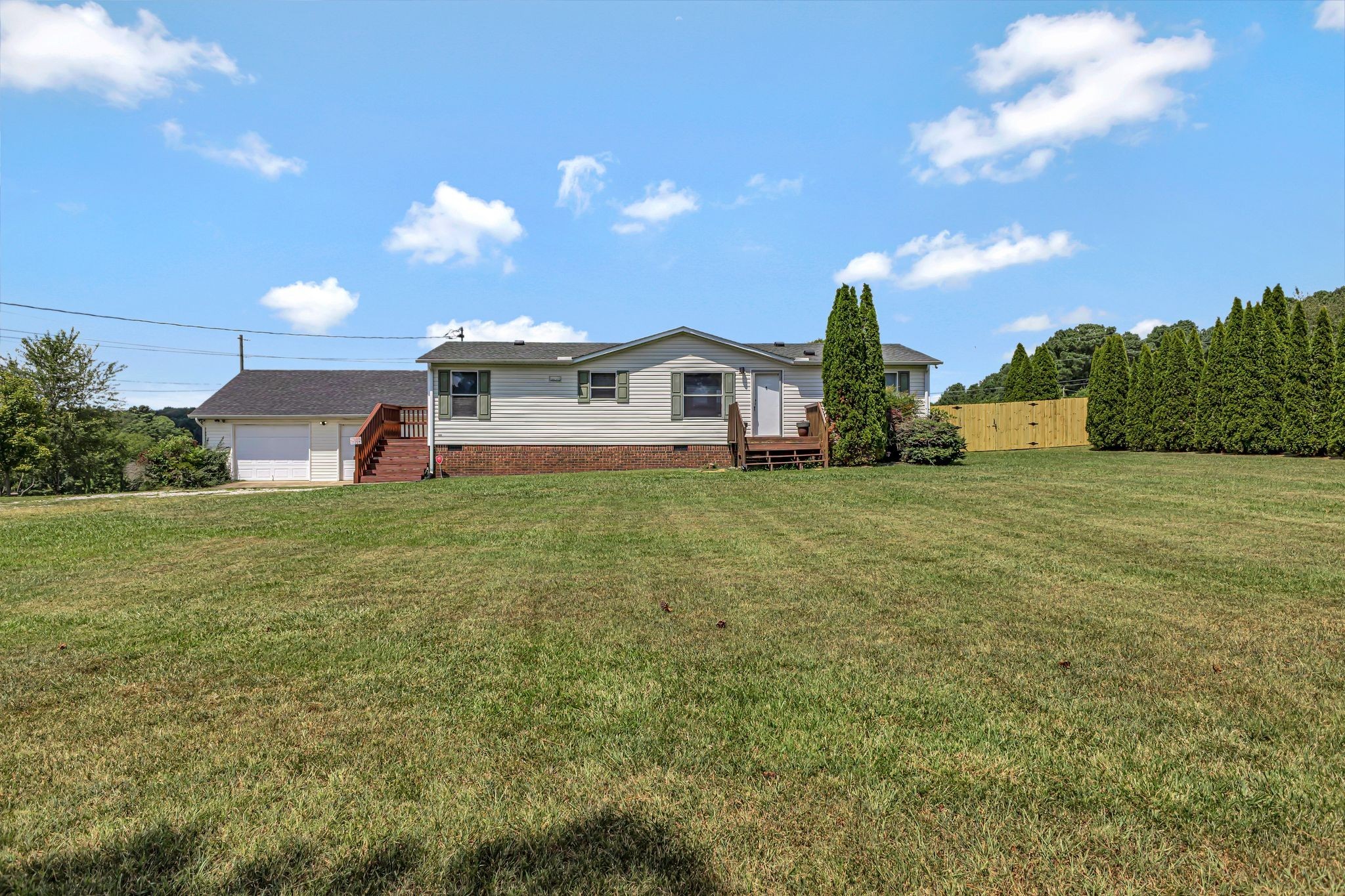 a view of a house with a big yard and a large tree