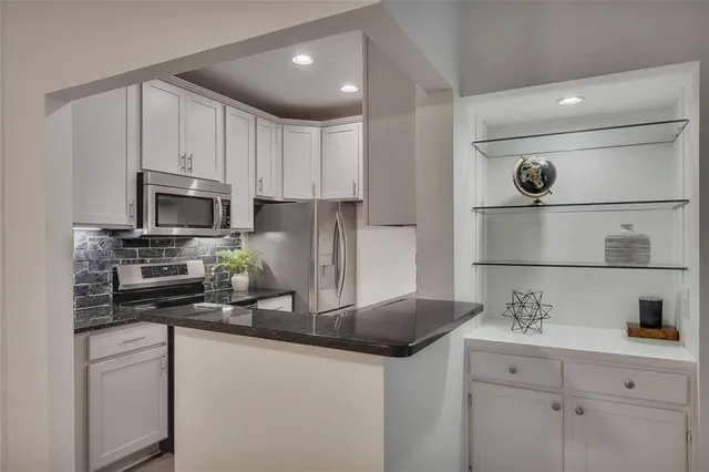 a kitchen with appliances a sink and cabinets