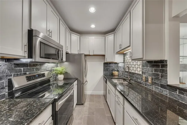 a kitchen with stainless steel appliances granite countertop a sink stove microwave and cabinets