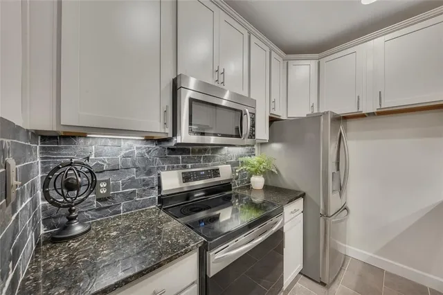 a kitchen with granite countertop a stove and a refrigerator