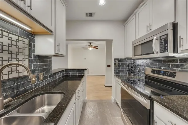 a kitchen with a sink stove and cabinets