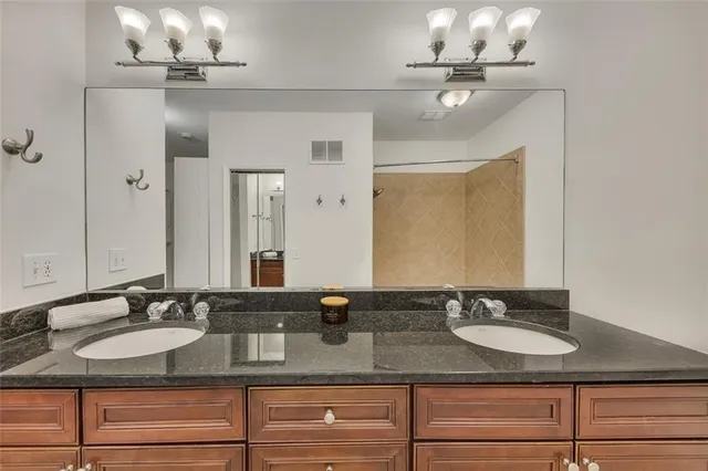 a bathroom with double vanity sinks and a mirror