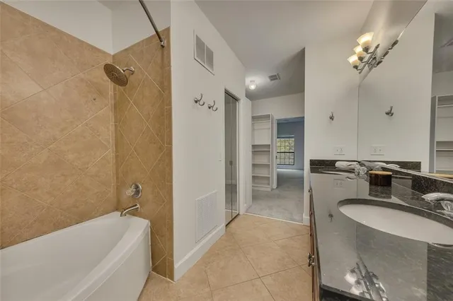a bathroom with a tub sink and mirror