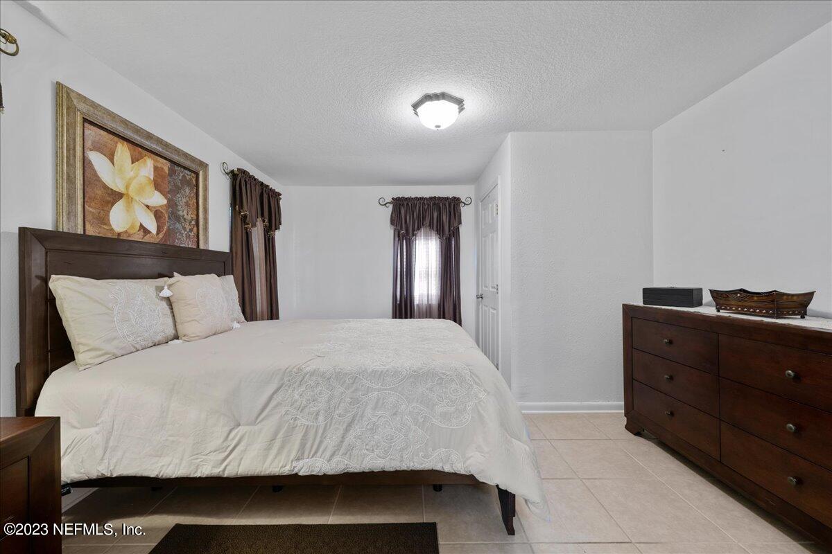 113 Leaf Street San Mateo, FL 32187 - Photo 16 of 32 a bedroom with a bed and a dresser