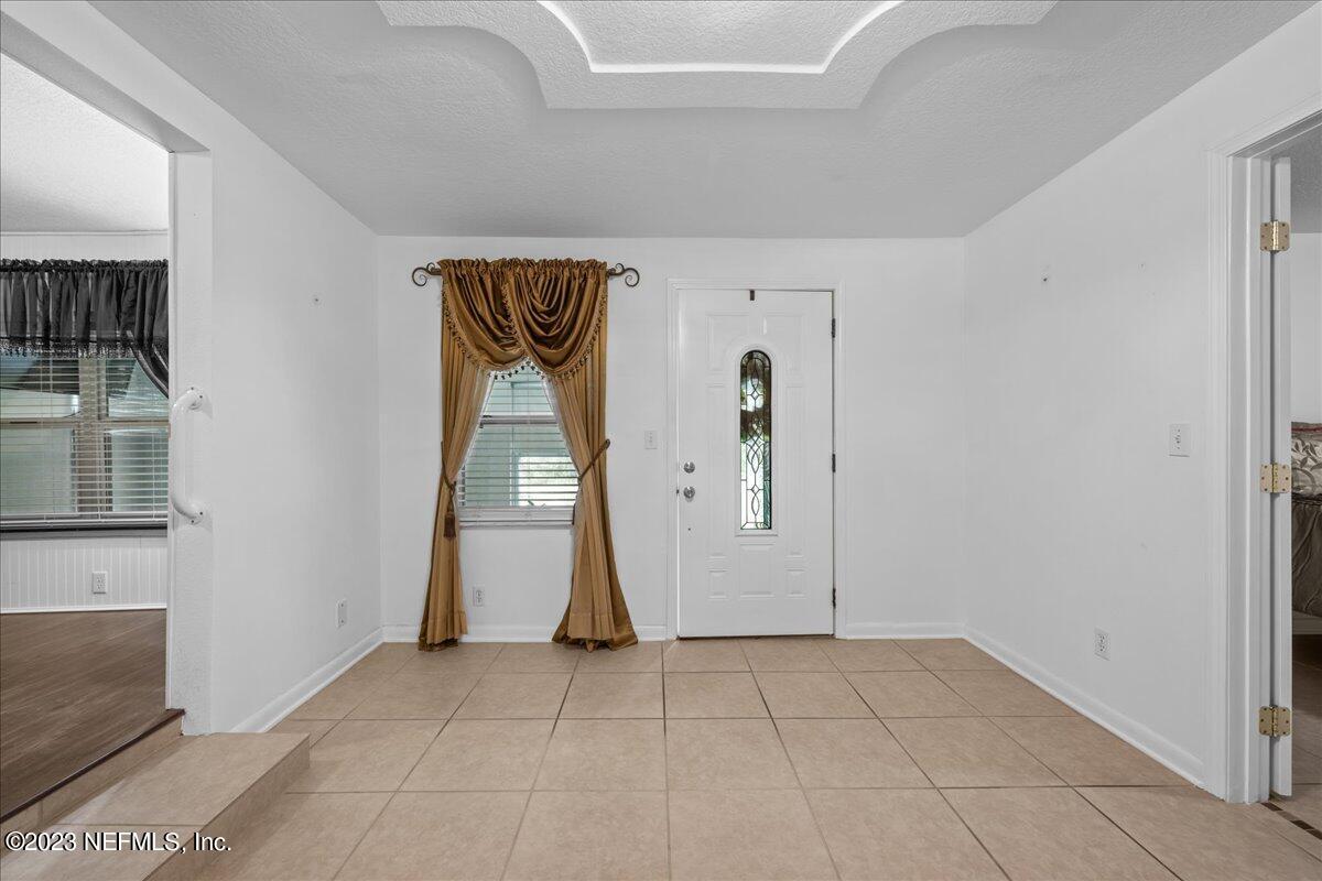 113 Leaf Street San Mateo, FL 32187 - Photo 21 of 32 a view of an empty room with wooden floor and a fireplace