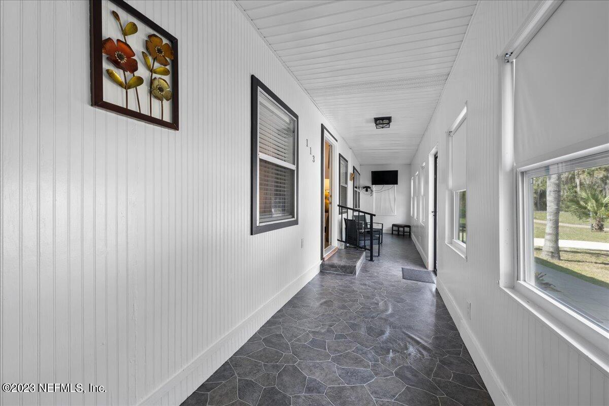 113 Leaf Street San Mateo, FL 32187 - Photo 6 of 32 a living room with furniture a large window and a wooden door