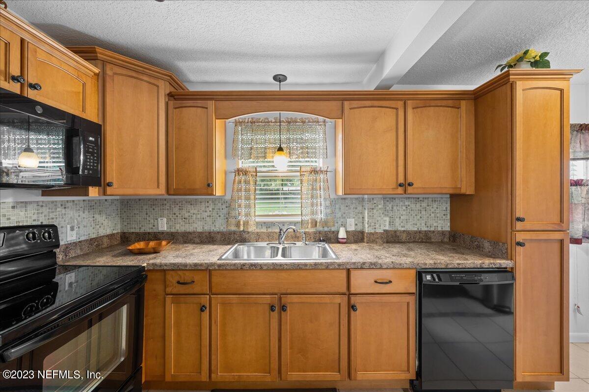 113 Leaf Street San Mateo, FL 32187 - Photo 10 of 32 a kitchen with granite countertop stainless steel appliances a sink stove and cabinets