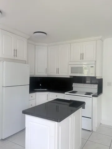a kitchen with a sink and white cabinets