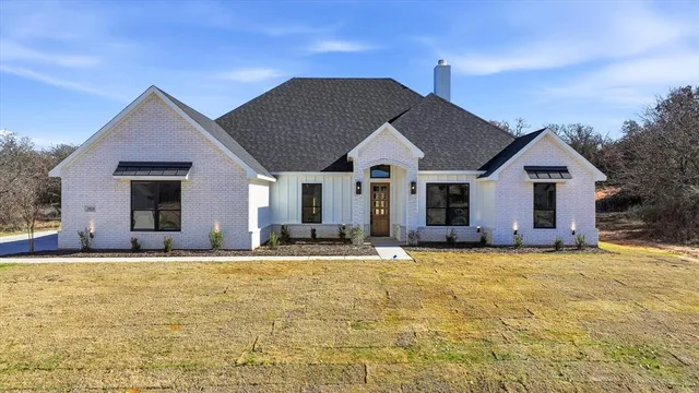 a view of a house with a yard and potted plants