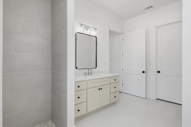a bathroom with white cabinets and sink