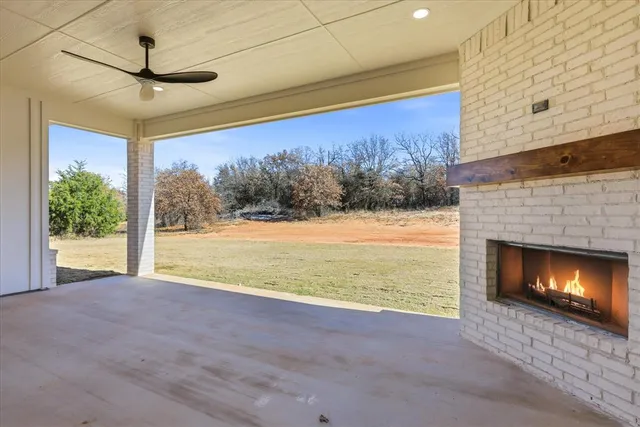 a view of empty room with floor to ceiling window and fireplace