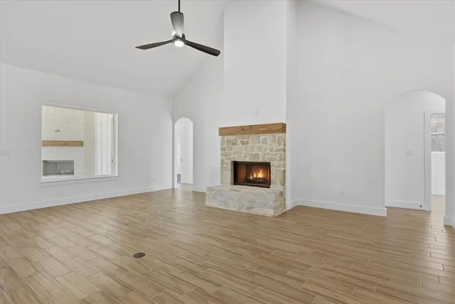 a view of empty room with wooden floor and fireplace
