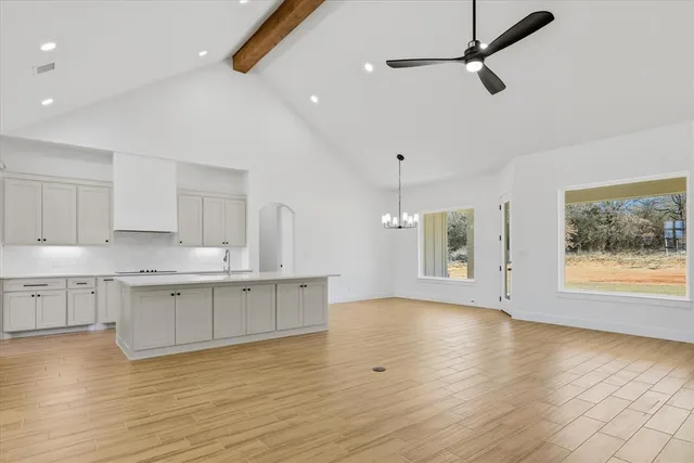 a large kitchen with stainless steel appliances granite countertop a stove and a wooden floors
