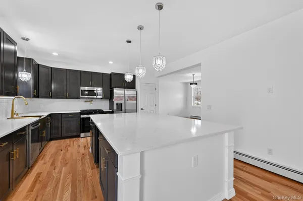 a kitchen with kitchen island a sink stove and refrigerator
