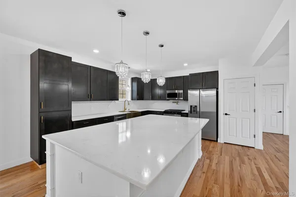 a large white kitchen with a large counter top appliances and cabinets