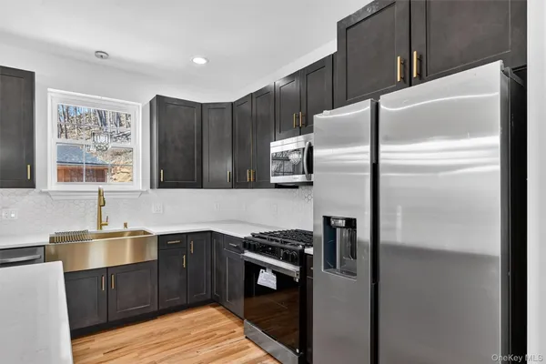 a kitchen with granite countertop a refrigerator and a sink