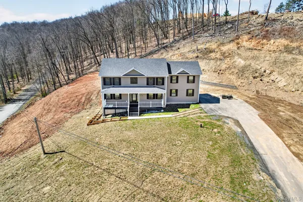 a front view of a house with a large tree