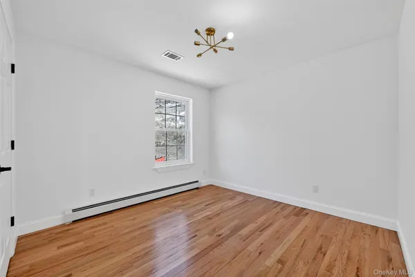 a view of room with window and wooden floor