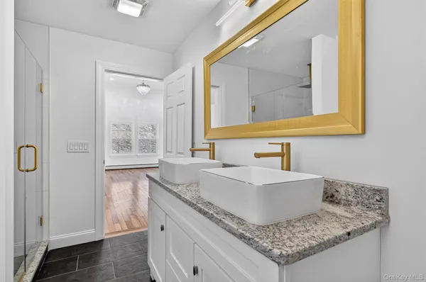 a bathroom with a granite countertop sink and a mirror