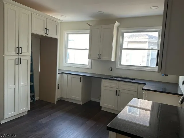 a kitchen with wooden floors and windows