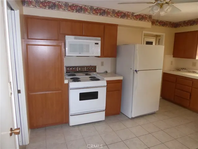 a white refrigerator freezer and a stove sitting inside of a kitchen