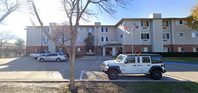 a front view of a house with cars parked