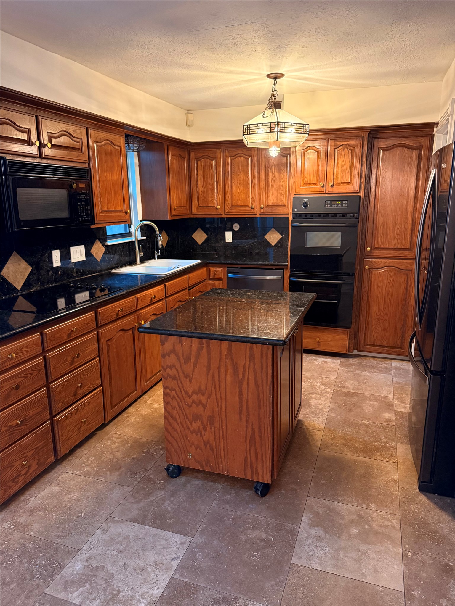 2311 Peppermill Road Houston, TX 77080 - Photo 6 of 18 a kitchen with granite countertop a refrigerator and wooden cabinets