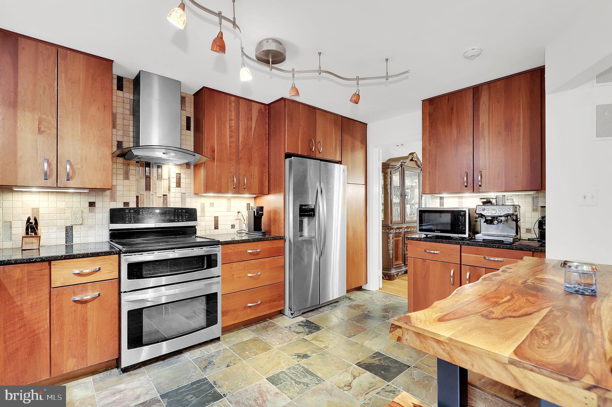 10804 Brewer House Road Rockville, MD 20852 - Photo 15 of 39 a kitchen with stainless steel appliances granite countertop a stove refrigerator sink and cabinets