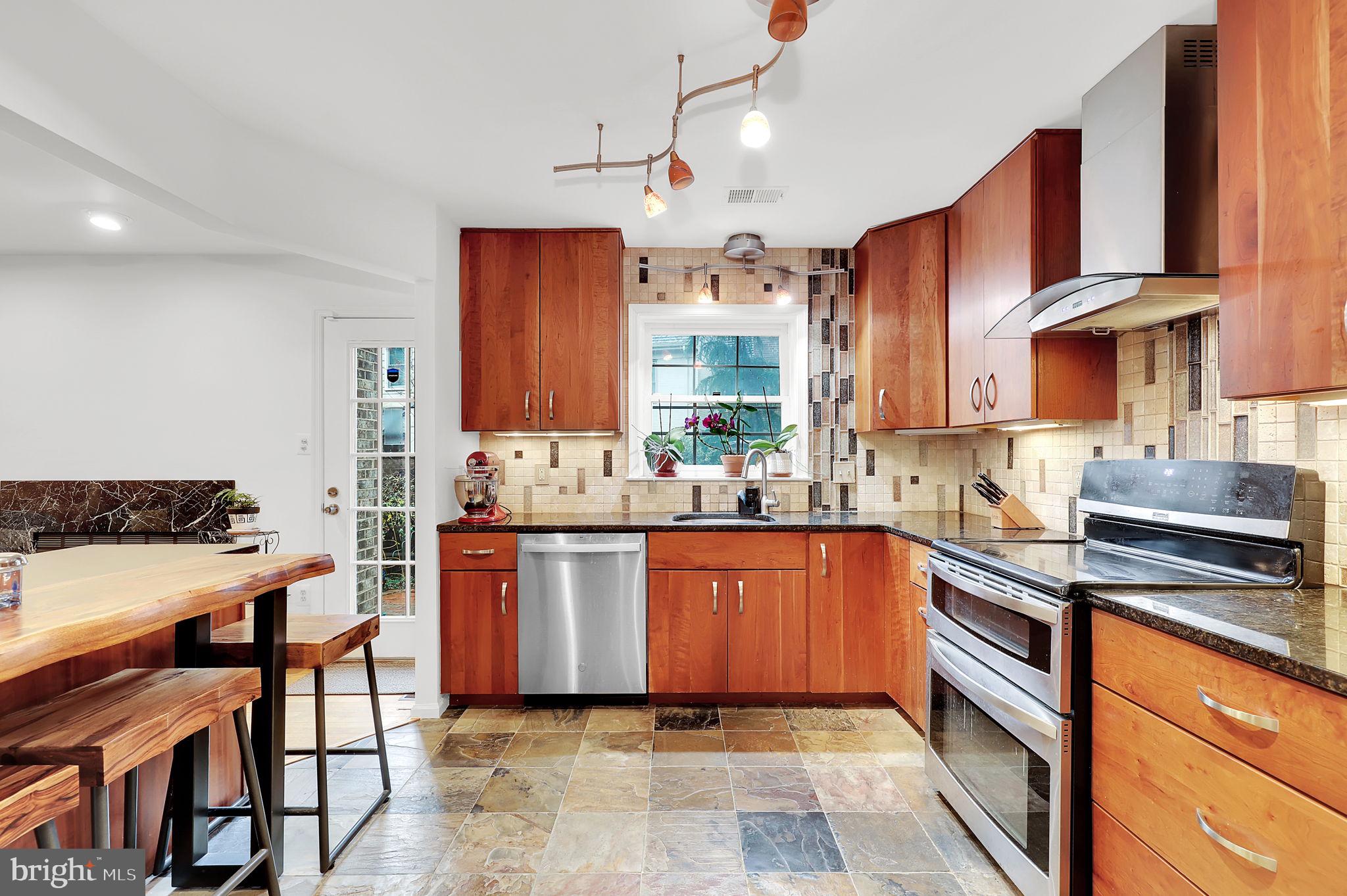 10804 Brewer House Road Rockville, MD 20852 - Photo 16 of 39 a kitchen with stainless steel appliances granite countertop a sink and a stove