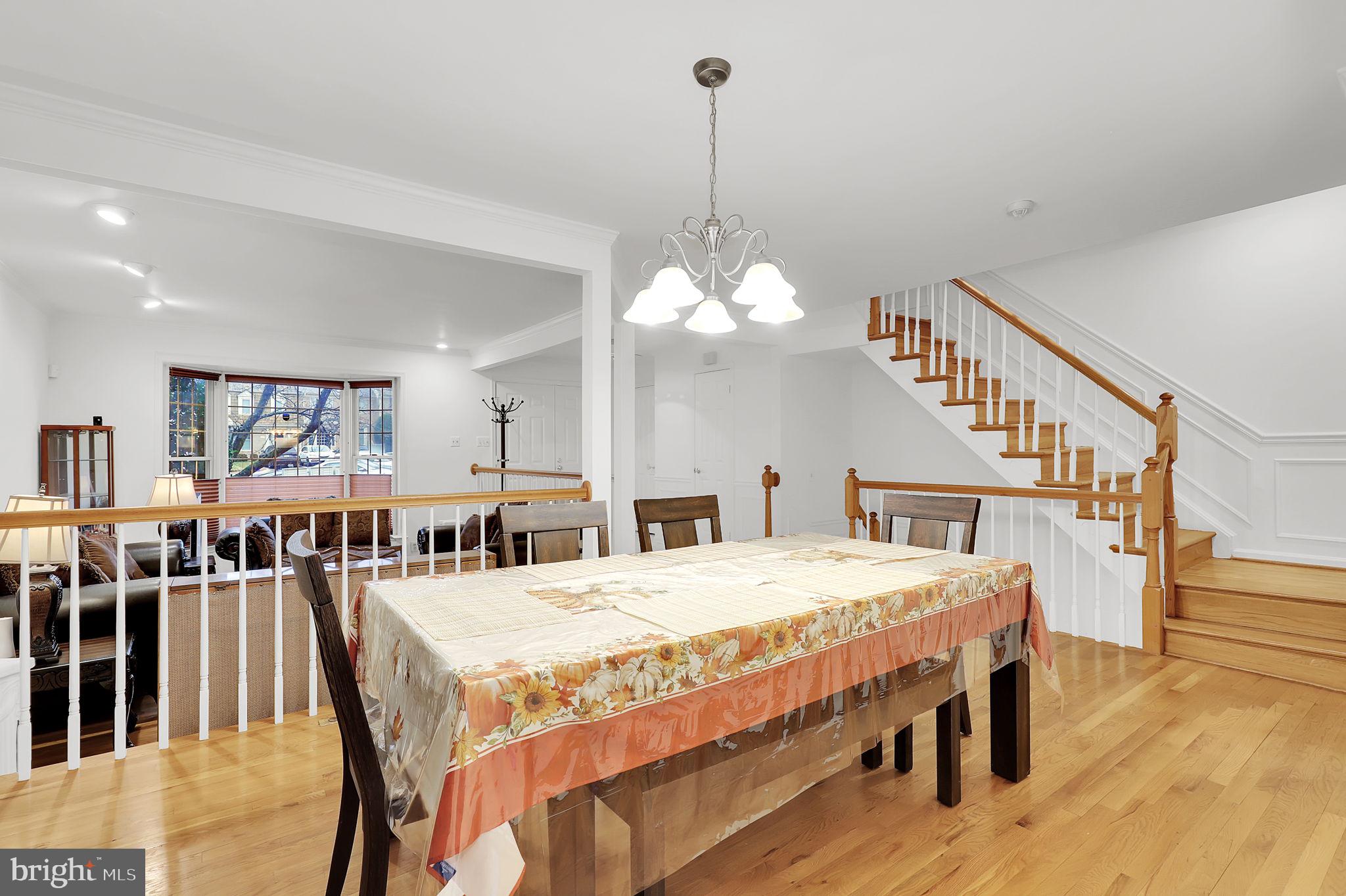 10804 Brewer House Road Rockville, MD 20852 - Photo 16 of 79 a dining room with a table chairs and a wooden floor