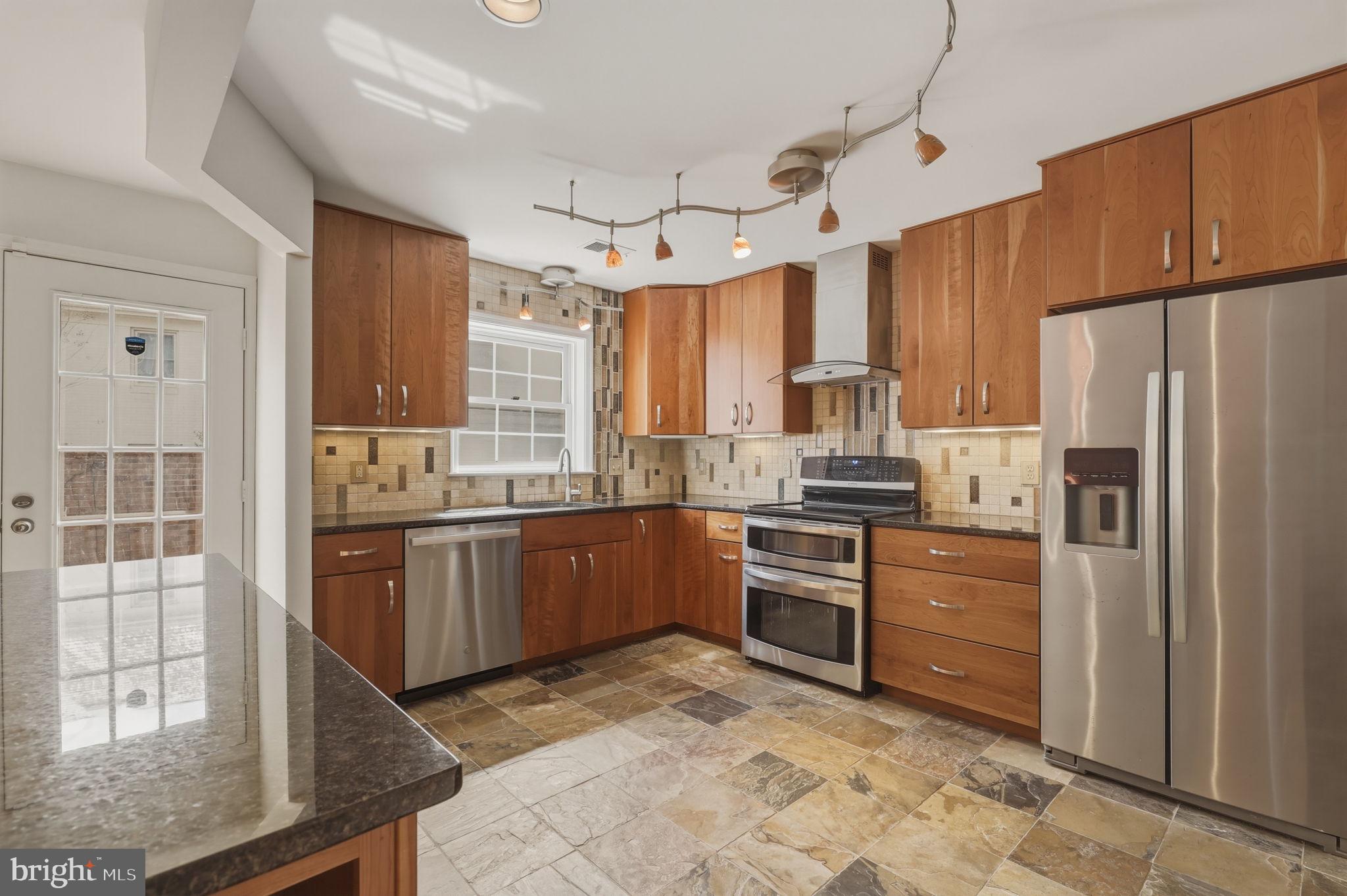 10804 Brewer House Road Rockville, MD 20852 - Photo 29 of 79 a kitchen with granite countertop a refrigerator stove top oven and sink