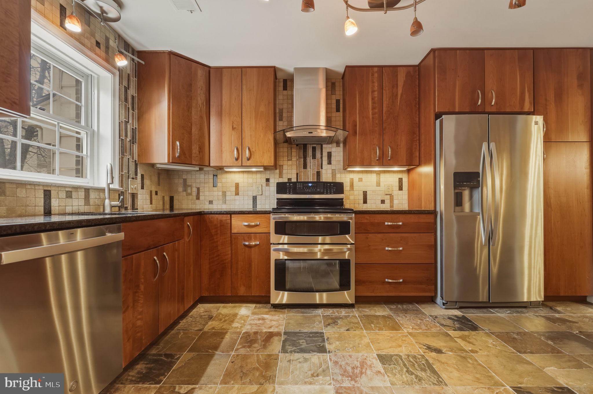 10804 Brewer House Road Rockville, MD 20852 - Photo 33 of 79 a kitchen with stainless steel appliances granite countertop a refrigerator and a sink