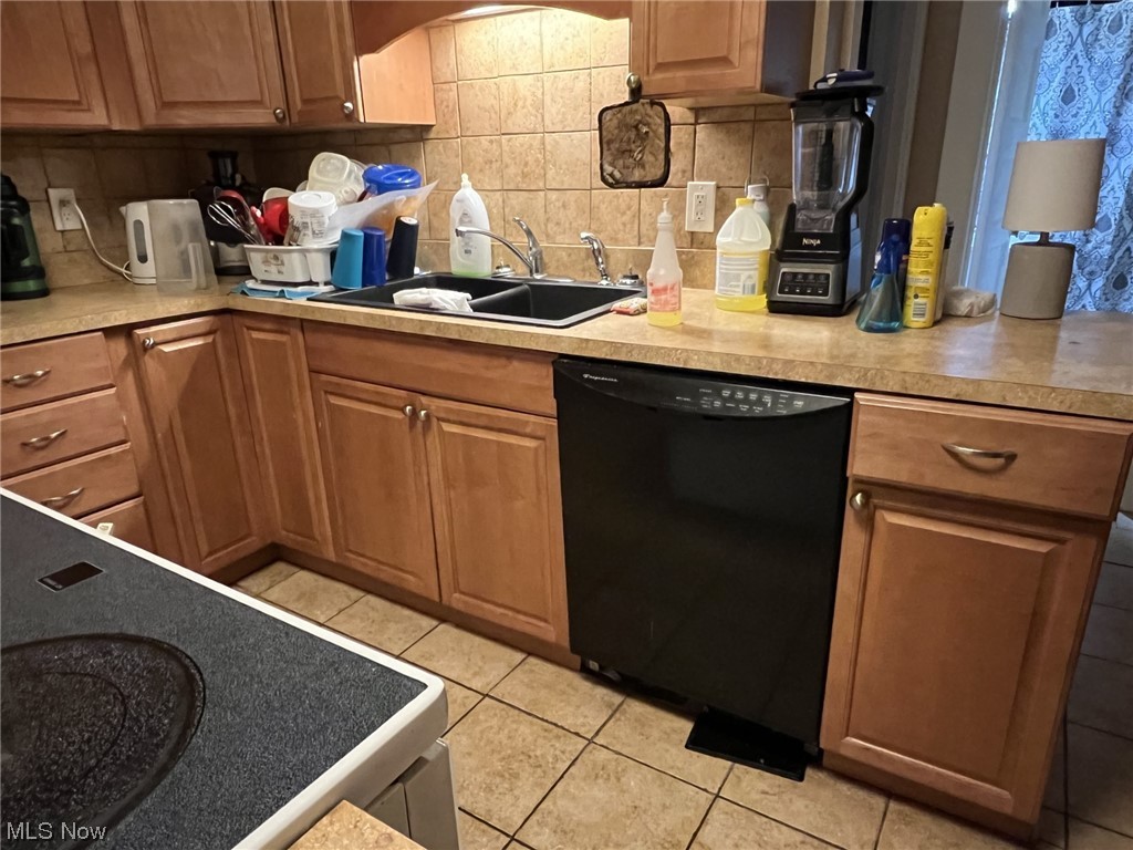 976 Nathaniel Road Cleveland, OH 44110 - Photo 8 of 15 Kitchen with tasteful backsplash, dishwasher, sink, and light tile floors