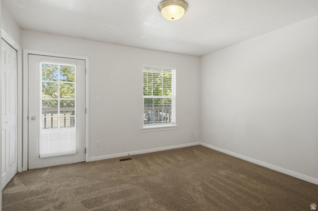 794 East 950 S Street Provo, UT 84606 - Photo 15 of 28 Carpeted room with a white door featuring full-light glass panels, a window with blinds, and white baseboards