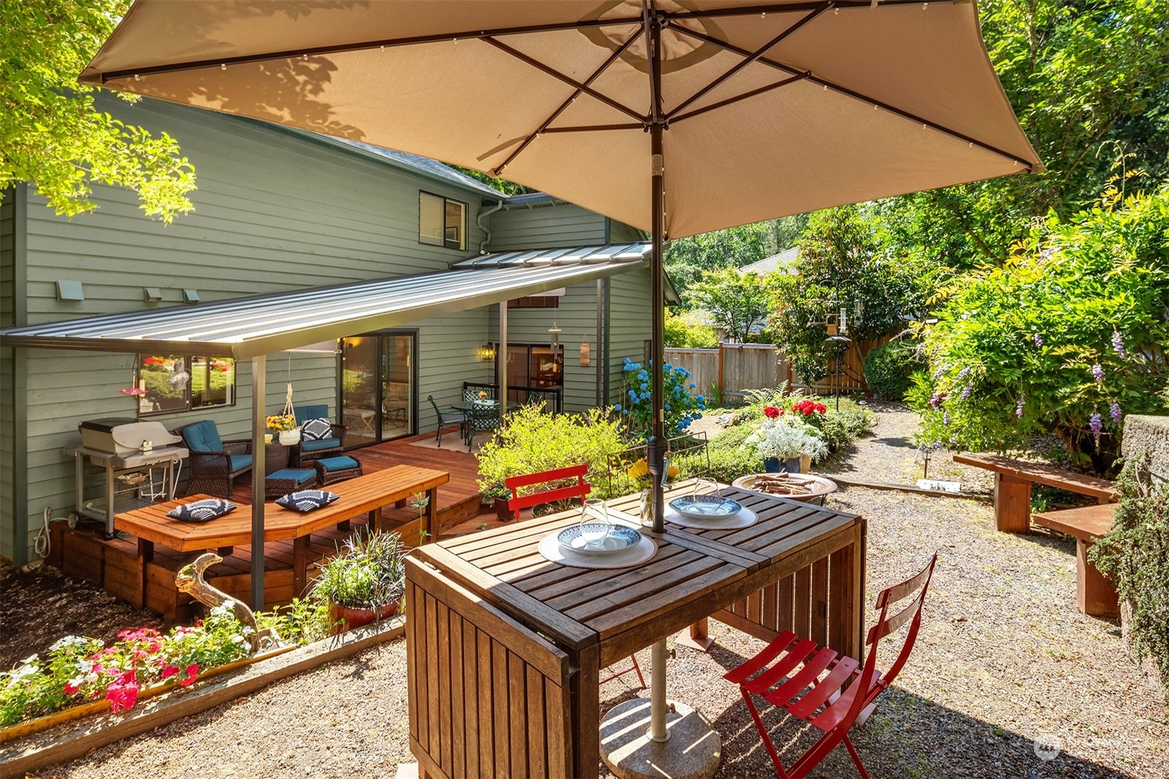 21127 Shell Valley Road Edmonds, WA 98026 - Photo 13 of 40 a view of a patio with couches table and chairs under an umbrella