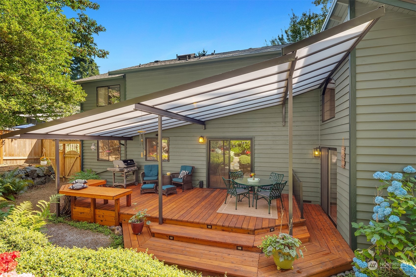 21127 Shell Valley Road Edmonds, WA 98026 - Photo 15 of 40 a view of a patio with table and chairs potted plants and floor to ceiling window
