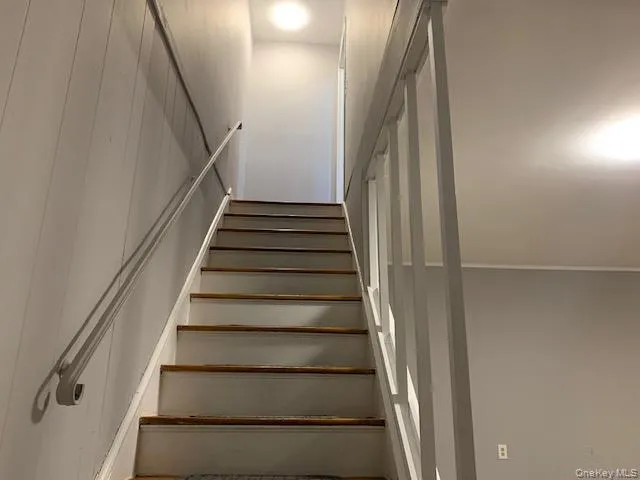 a view of staircase with white walls and a window