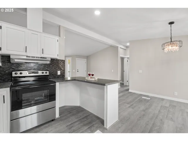 a kitchen with stainless steel appliances granite countertop a stove and a sink
