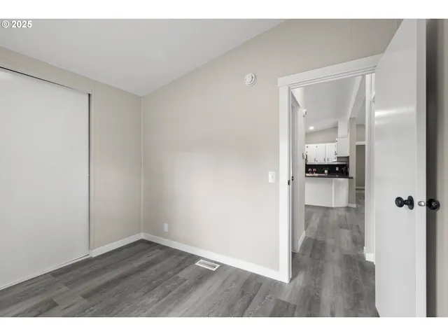 a view of empty room with wooden floor