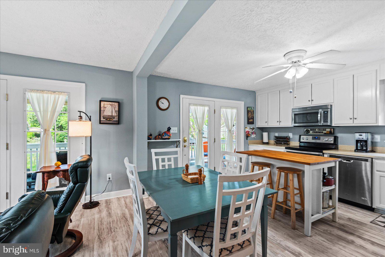 720 Bancroft Avenue Colonial Beach, VA 22443 - Photo 15 of 59 a kitchen with stainless steel appliances granite countertop a dining table chairs refrigerator and sink