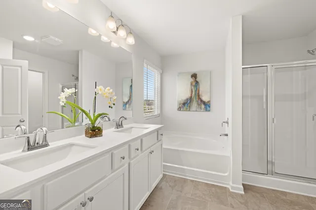 a bathroom with a double vanity sink a mirror a bathtub and next to a window