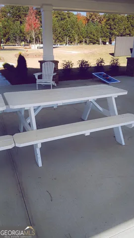 a view of a lake with a table and chairs in wooden floor