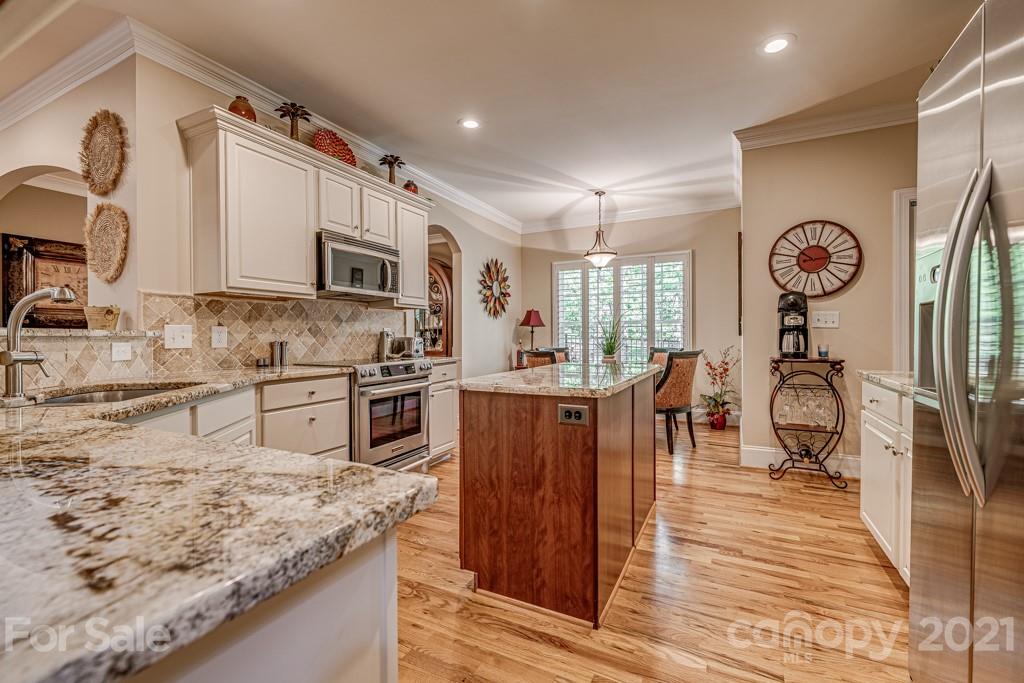 4367 Lake Shore Road North Denver, NC 28037 - Photo 12 of 48 a kitchen with stainless steel appliances granite countertop a stove top oven a sink a dining table and chairs with wooden floor