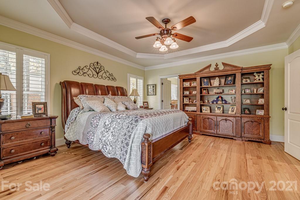 4367 Lake Shore Road North Denver, NC 28037 - Photo 20 of 48 a bedroom with a large bed a chandelier and a book shelf