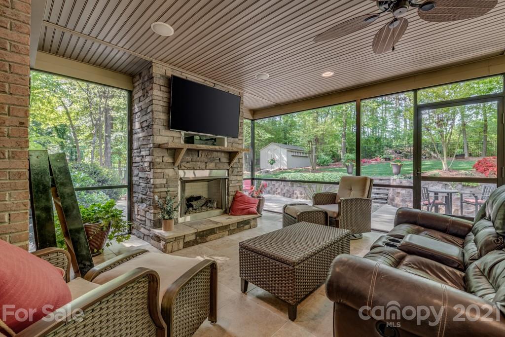 4367 Lake Shore Road North Denver, NC 28037 - Photo 38 of 48 a living room with furniture a flat screen tv and a floor to ceiling window