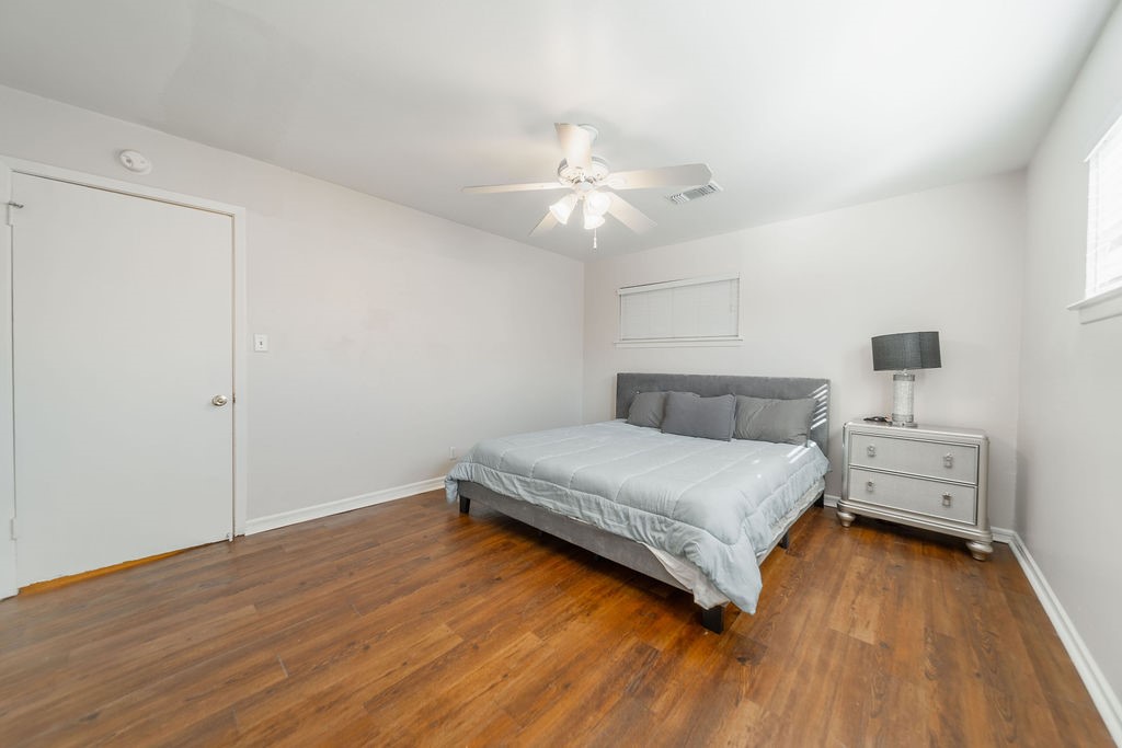 4723 Merwin Street Houston, TX 77027 - Photo 14 of 29 a bedroom with a bed and wooden floor