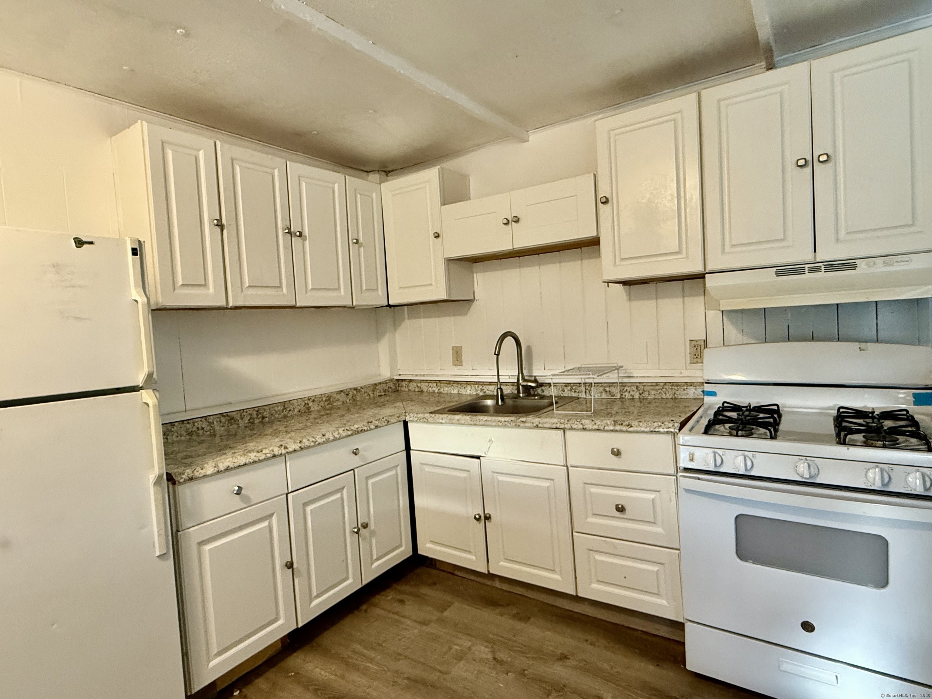 243 Champion Road Franklin, CT 06254 - Photo 8 of 13 a kitchen with granite countertop white cabinets and white appliances