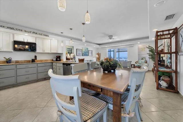 a kitchen with a table chairs refrigerator and microwave